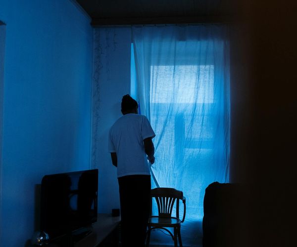 Person meditating peacefully in a softly lit room.